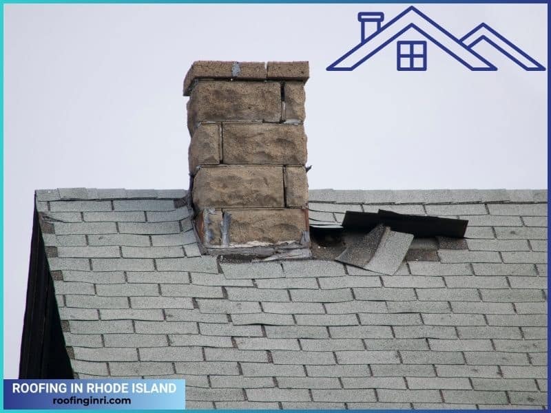 Damaged flashing and old roofing shingles on a house