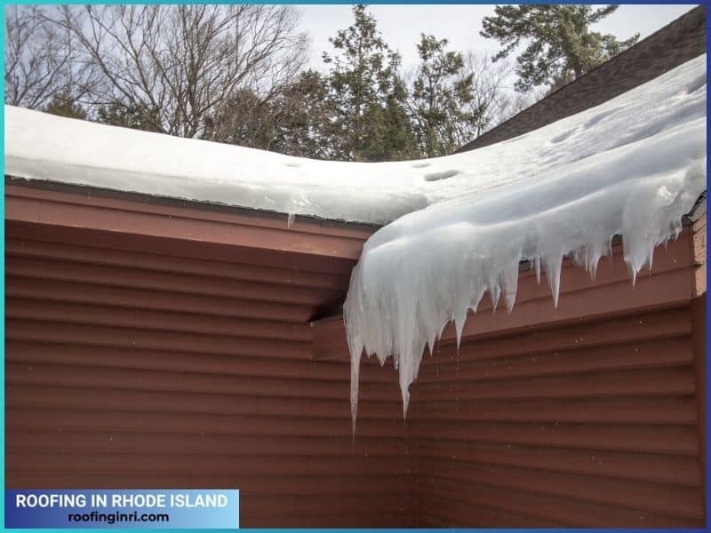 Icicles Hang From Ice Dam On Home Roof With Water Dripping