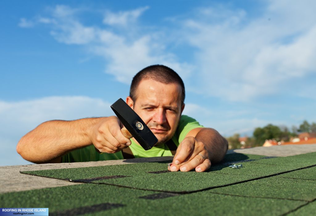 Man installing bitumen roof shingles
